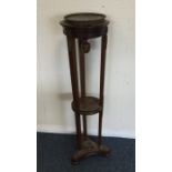 A late Victorian mahogany plant stand with brass m