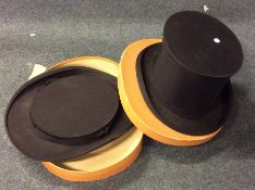 A pair of unusual collapsible bowler hats in a cas