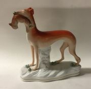 A tall Staffordshire figure of a greyhound with or