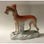 A tall Staffordshire figure of a greyhound with or