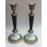 A pair of brass mounted and porcelain candlesticks