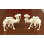 A pair of carved ivory figures of camels in standi