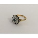 A circular sapphire and diamond daisy head cluster