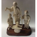 A large carved ivory group of three figures with r