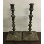 A pair of heavy brass Georgian style candlesticks