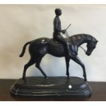 A large bronzed figure of a horse and rider on mar