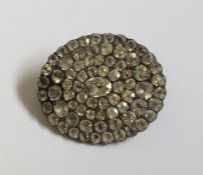 A Georgian oval brooch with large central stone. A