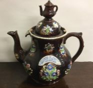 A massive pottery teapot decorated with flowers to