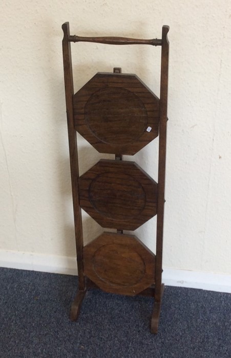 An oak cake stand. Est. £20 - £30.