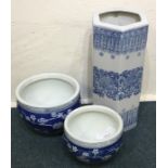 Two large blue and white planters together with a
