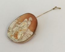 An oval gold framed cameo depicting figures. Appro