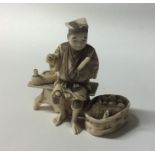 A carved ivory figure of a man in seated position.