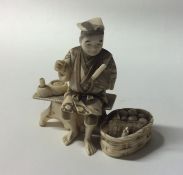 A carved ivory figure of a man in seated position.