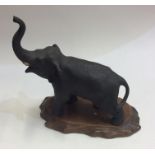 A Chinese model of an elephant on wooden base. Est