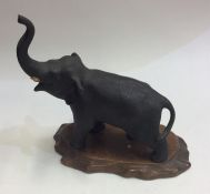 A Chinese model of an elephant on wooden base. Est