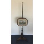 A Victorian pole screen on shaped base with cut co