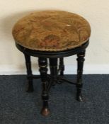 An ebony and tapestry stool. Est. £20 - £30.