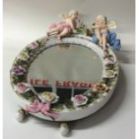 A decorative porcelain mirror mounted with bright