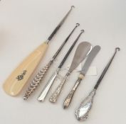 A collection of various silver button hooks. Est.