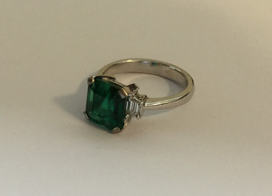 A good Art Deco emerald and diamond three stone ri