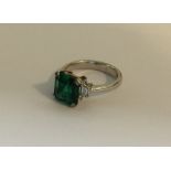 A good Art Deco emerald and diamond three stone ri