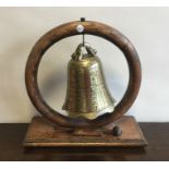 An oak and brass dinner gong of Chinese design on