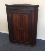 A Georgian oak corner cupboard with inlaid decorat