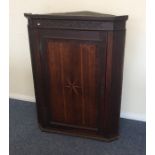 A Georgian oak corner cupboard with inlaid decorat