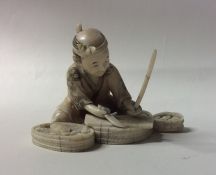 A carved ivory figure of a fisherman in seated pos