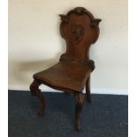 An oak carved hall chair. Est. £25 - £35.
