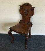 An oak carved hall chair. Est. £25 - £35.