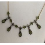 An Art Nouveau style peridot and diamond fringe ne