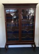 A Georgian mahogany two door glazed cabinet on cab