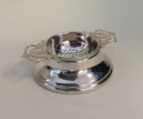 An Edwardian silver tea strainer with pierced hand