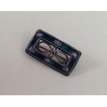 A small rectangular silver brooch with enamel deco