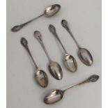 A set of six silver teaspoons with scroll handles.