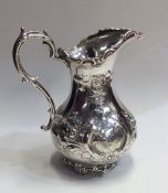 A large Victorian silver embossed cream jug with s