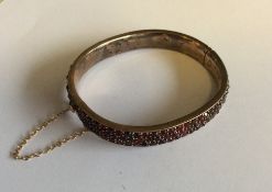 An Antique three row garnet bangle with concealed