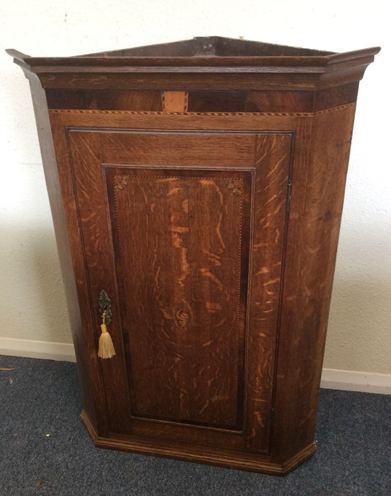 A Georgian crossbanded oak corner cupboard. Est. £