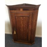 A Georgian crossbanded oak corner cupboard. Est. £