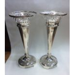 A tall pair of tapering silver spill vases with pi