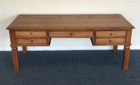 A large hardwood desk of five drawers on tapering