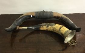 A pair of ornate bull horns together with an old h