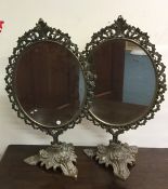 A pair of ornate dressing table mirrors on sweepin