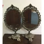 A pair of ornate dressing table mirrors on sweepin