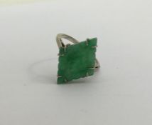 A carved jade single stone ring in claw mount. App