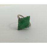 A carved jade single stone ring in claw mount. App