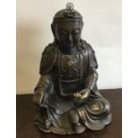 A large bronzed figure of a seated Buddha with a f
