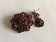 A gold mounted circular garnet brooch together wit