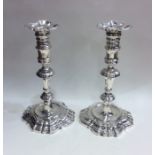 A good pair of George II cast silver candlesticks